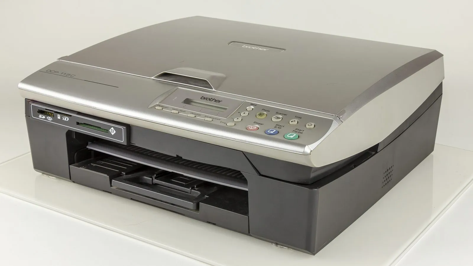 Impressora multifuncional doméstica de mesa, com tampa do scanner fechada e bandeja de papel aberta.