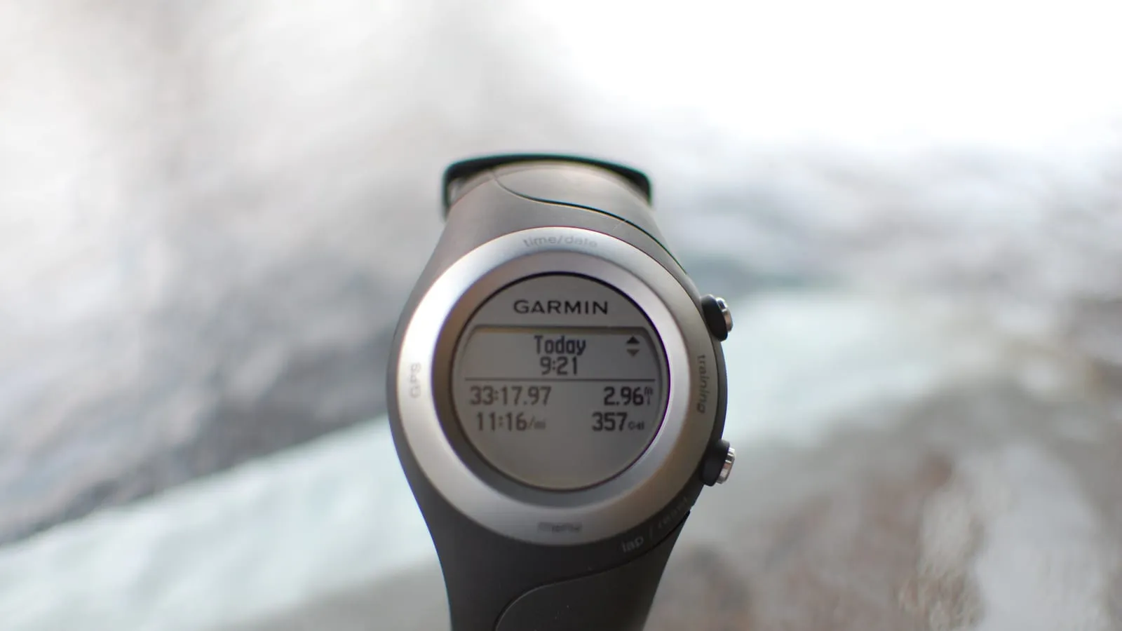 Relógio de GPS Garmin com a tela mostrando tempo, distância, ritmo e calorias de um treino.