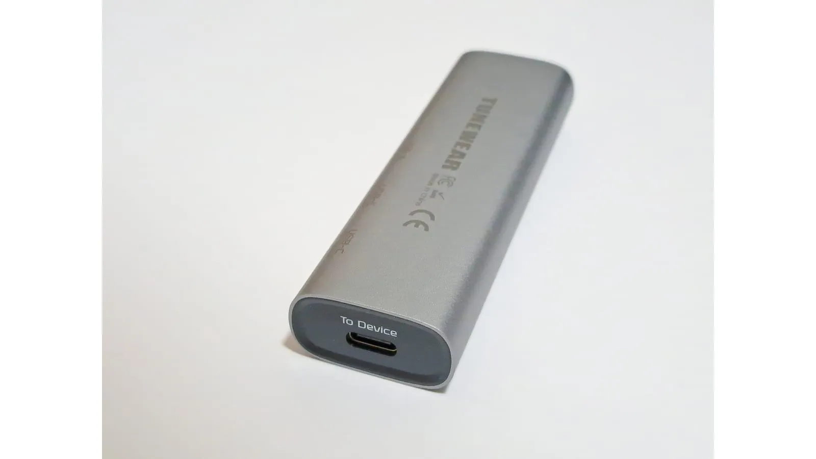 Hub USB-C de alumínio visto de perto, com a porta de conexão ao notebook em destaque.