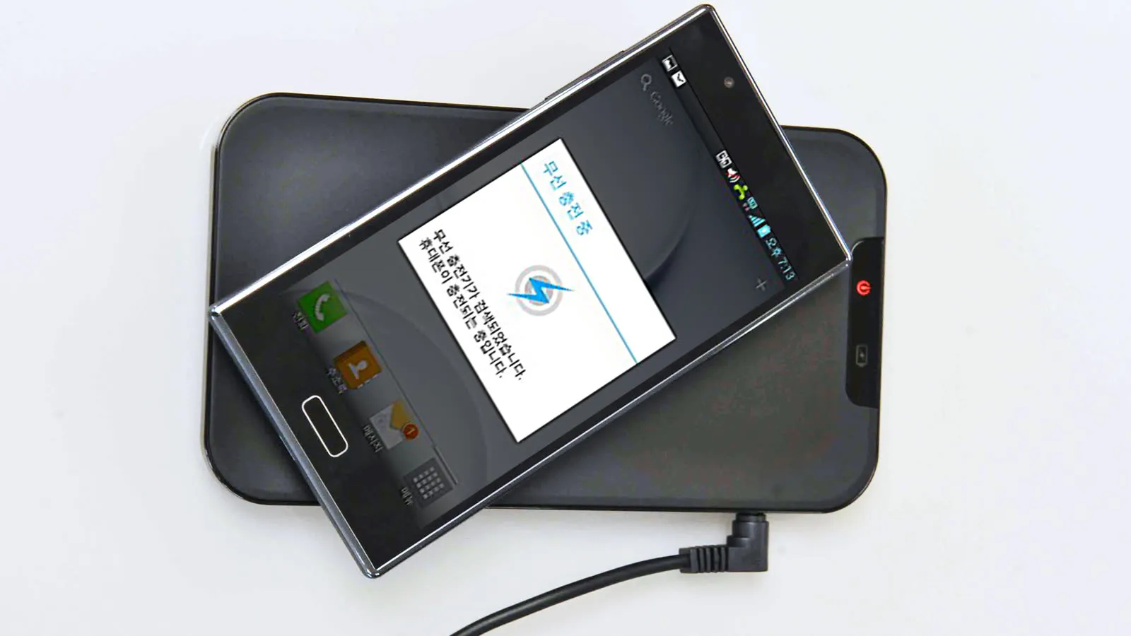 Celular apoiado sobre uma base de carregamento sem fio ligada na tomada.